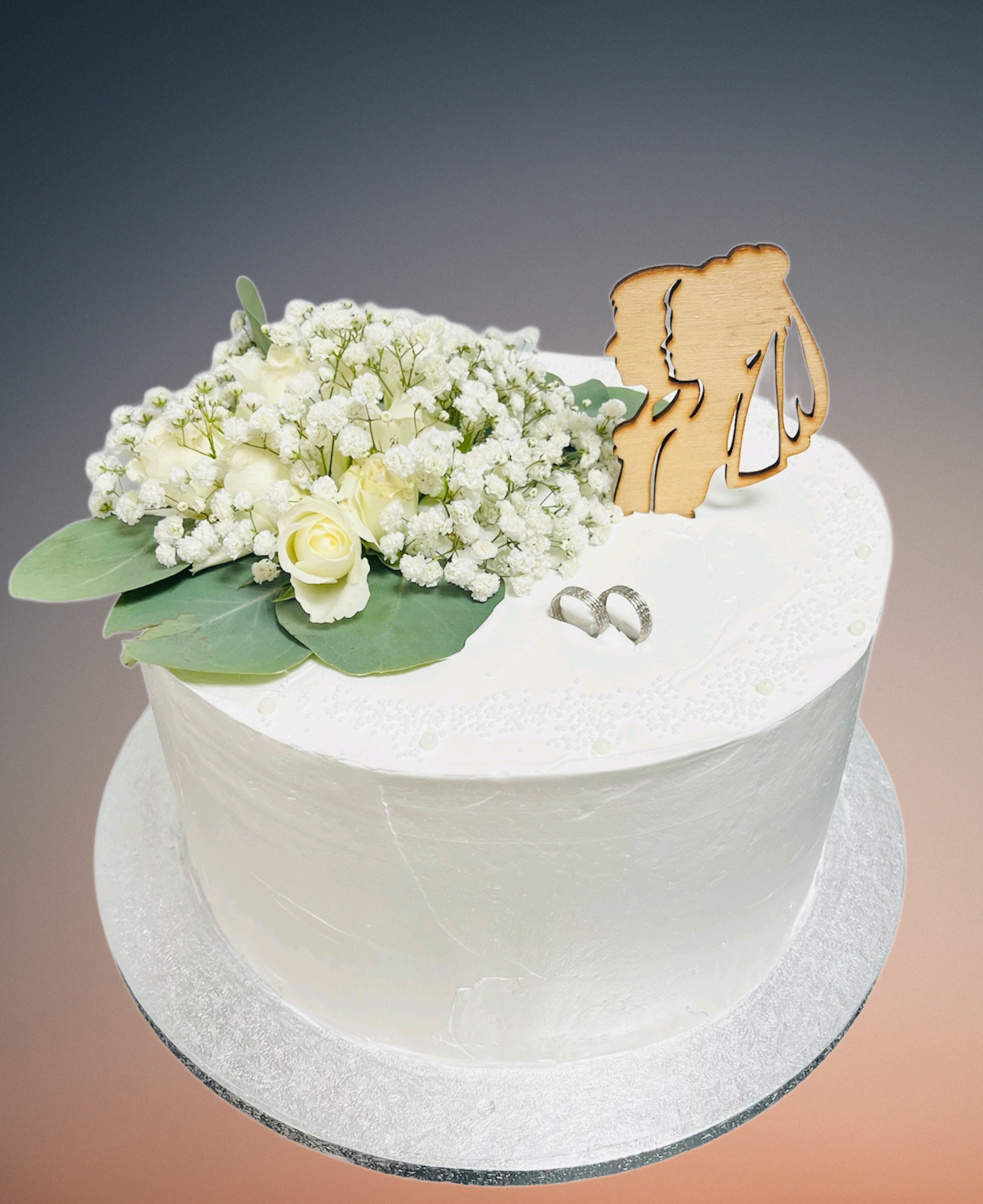 Elegantná biela svadobná torta s jemnou kvetinovou dekoráciou Elegantná biela svadobná torta s jemnou kvetinovou dekoráciou